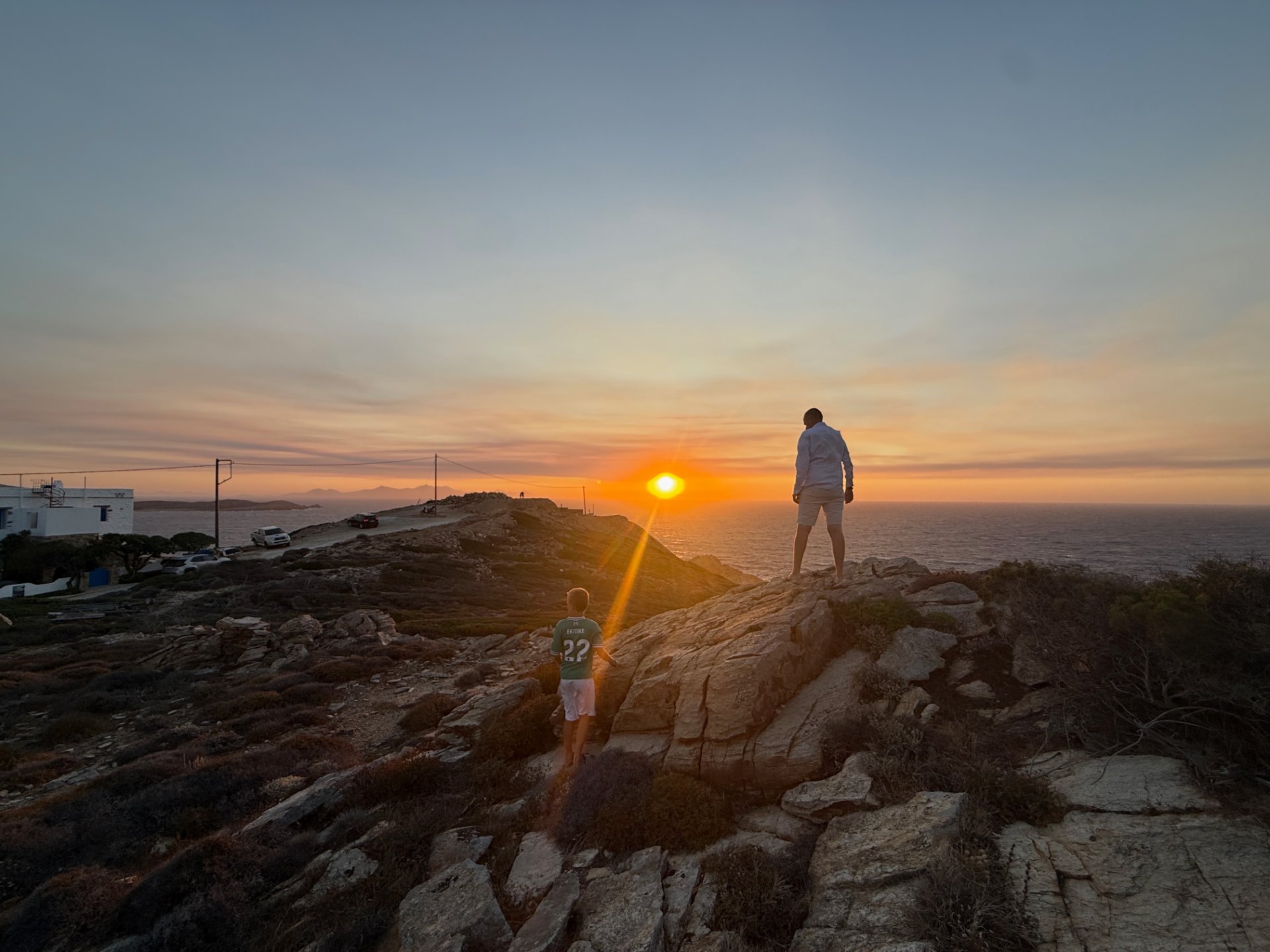 Øystein and Amund among the rocks on the Akri House site as the sun sets over the Aegean Sea.