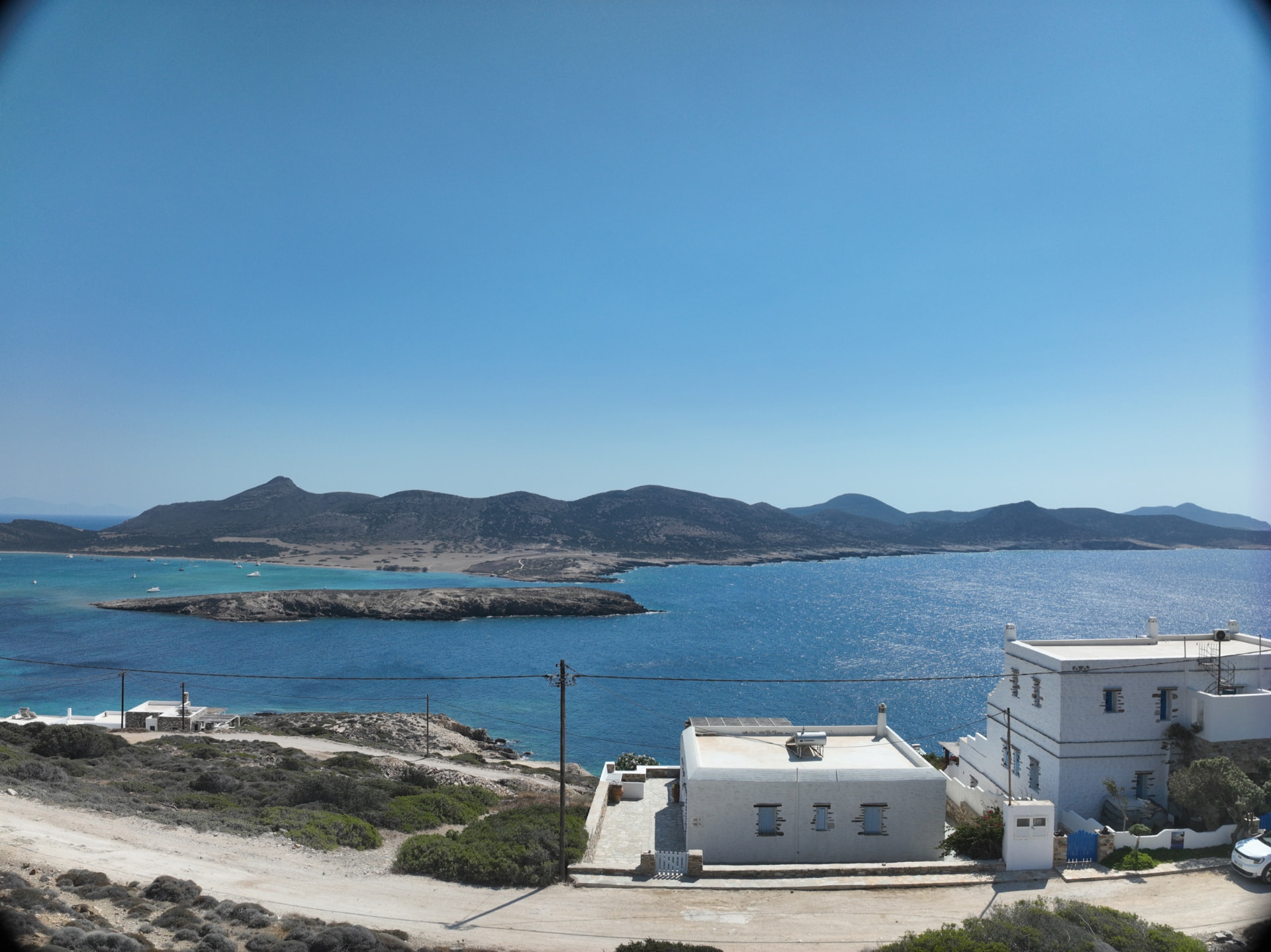 The calmer bay to the south, deep blue water and low Cycladic buildings.